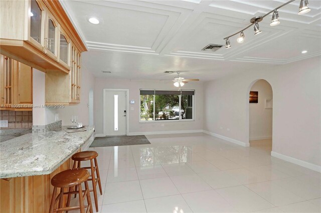 unfurnished living room featuring visible vents, baseboards, a ceiling fan, and light tile patterned flooring