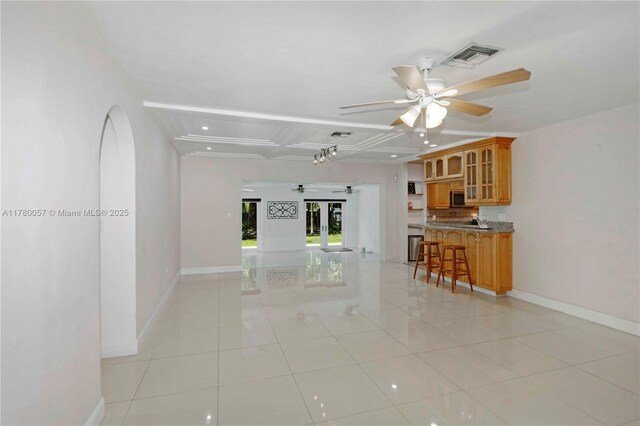 unfurnished living room featuring light tile patterned flooring, ceiling fan, baseboards, and visible vents
