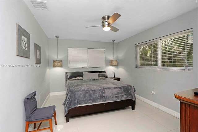 bedroom with light tile patterned floors, baseboards, visible vents, a ceiling fan, and a walk in closet