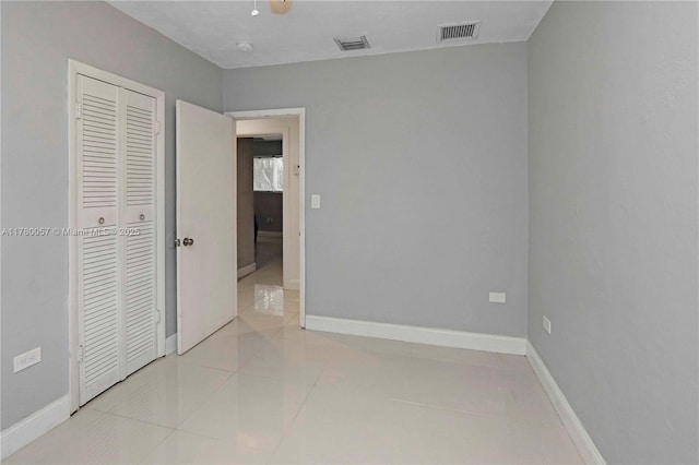 13130 NW 1st Ave, Miami, FL 33168 - unfurnished bedroom with a closet, baseboards, light tile patterned flooring, and ceiling fan