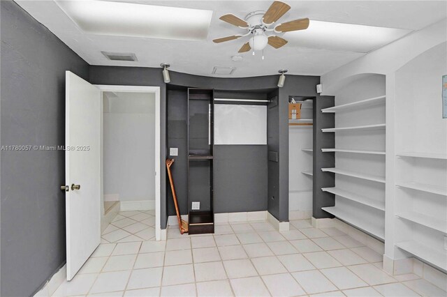 bathroom featuring toilet, tile walls, shower / bathtub combination with curtain, vanity, and wainscoting