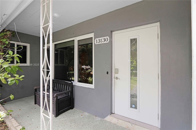 view of exterior entry with stucco siding
