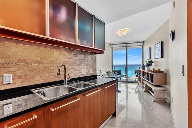 3101 S Ocean Dr Unit 2307, Hollywood, FL 33019 - kitchen with floor to ceiling windows, a sink, dark countertops, baseboards, and backsplash