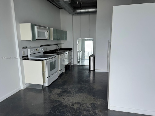 10 SW S River Dr Unit 812, Miami, FL 33130 - kitchen with white appliances, finished concrete floors, a towering ceiling, white cabinets, and dark countertops