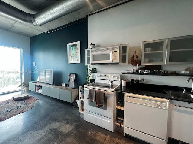 10 SW S River Dr Unit 812, Miami, FL 33130 - kitchen featuring white appliances, a sink, concrete flooring, dark countertops, and glass insert cabinets