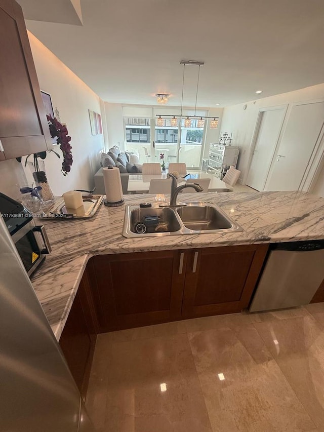 9499 Collins Ave Unit 411, Surfside, FL 33154 - kitchen featuring light stone countertops, dishwasher, open floor plan, and pendant lighting