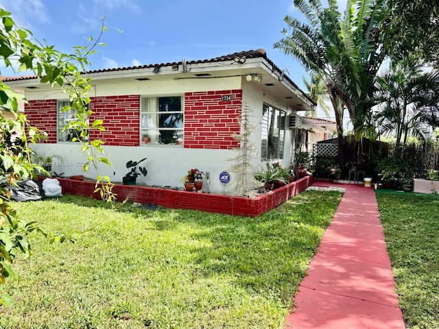 1734 Wiley St, Hollywood, FL 33020 - view of side of home featuring a yard, a tile roof, and brick siding