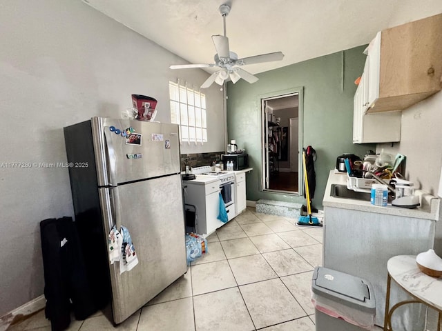 1734 Wiley St, Hollywood, FL 33020 - kitchen with light tile patterned floors, ceiling fan, freestanding refrigerator, light countertops, and white range with gas stovetop