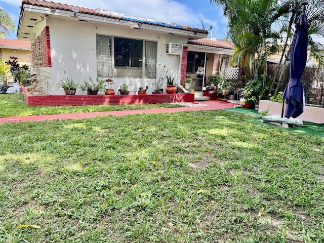 1734 Wiley St, Hollywood, FL 33020 - exterior space featuring a front yard, a tiled roof, a wall unit AC, and stucco siding