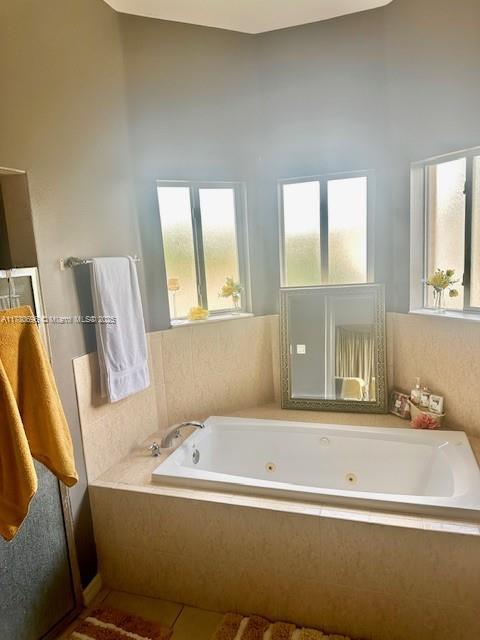 3315 18 W, Lehigh Acres, FL 33971 - full bath featuring a jetted tub and a healthy amount of sunlight
