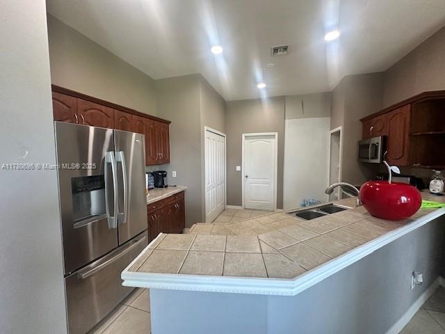 3315 18 W, Lehigh Acres, FL 33971 - kitchen with light tile patterned floors, a peninsula, visible vents, appliances with stainless steel finishes, and a sink