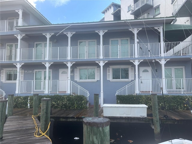 view of front of home featuring stucco siding, french doors, and a boat dock