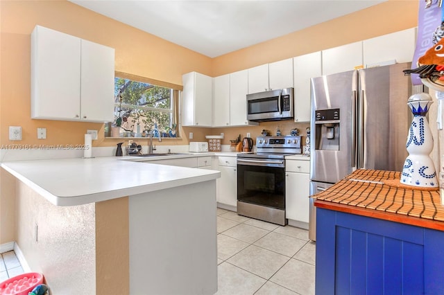 14070 SW 50th Ct, Miramar, FL 33027 - kitchen with appliances with stainless steel finishes, a sink, light tile patterned floors, a peninsula, and light countertops