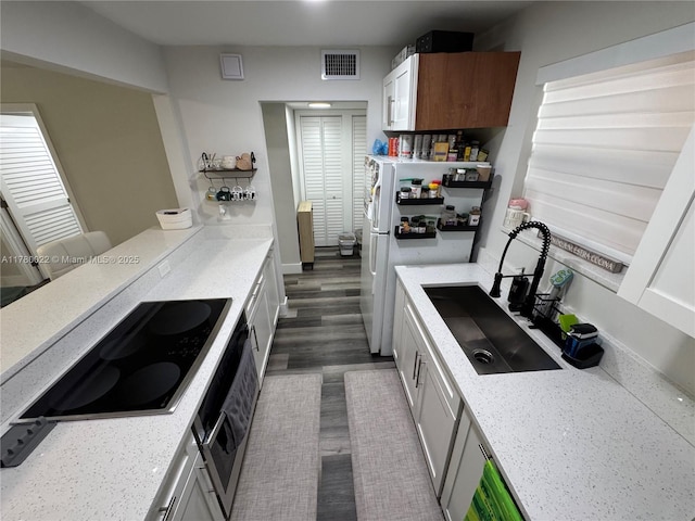 1235 Mariposa Ave Unit 1, Coral Gables, FL 33146 - kitchen featuring visible vents, a sink, freestanding refrigerator, wall oven, and black electric stovetop
