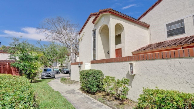 331 Ives Dairy Rd Unit 331-09, Miami, FL 33179 - view of property exterior featuring a tile roof and stucco siding