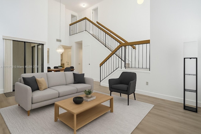 331 Ives Dairy Rd Unit 331-09, Miami, FL 33179 - living area featuring light wood-style floors, a towering ceiling, stairs, and baseboards