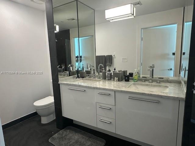 bathroom with toilet and double vanity