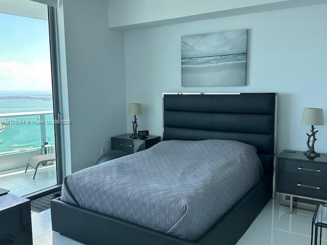 bedroom featuring a water view and access to outside