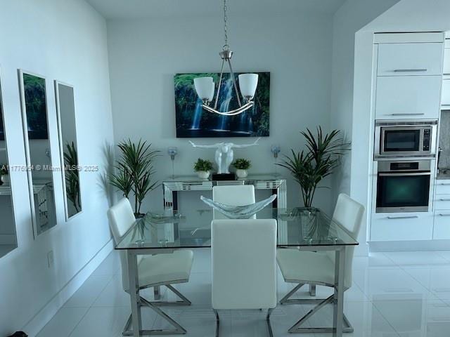 dining area with a chandelier and tile patterned floors