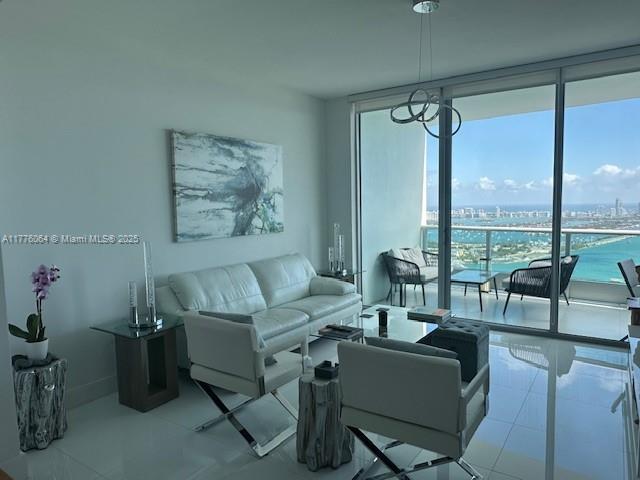 living area featuring a wall of windows and tile patterned floors