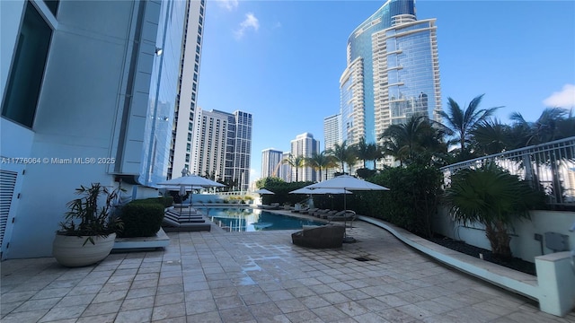 community pool with a city view and a patio