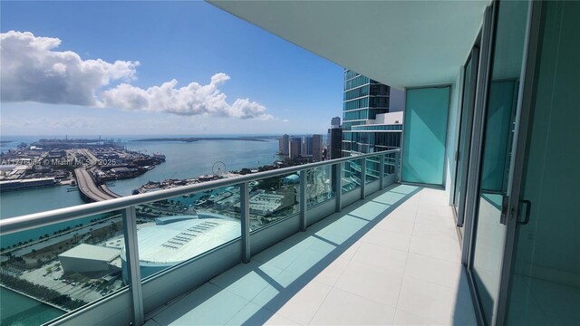 balcony with a water view and a view of city