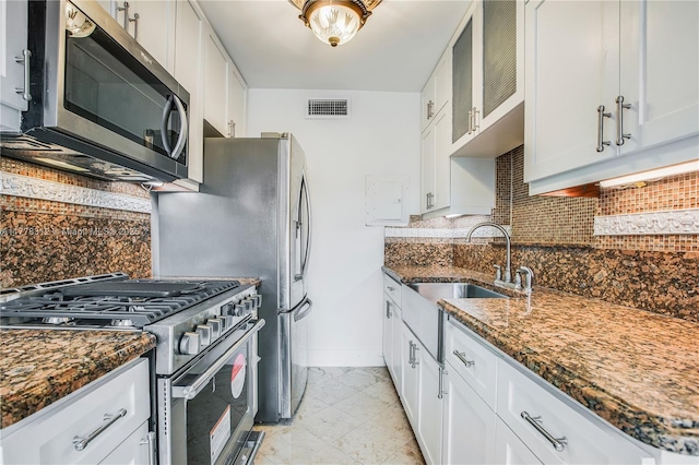 kitchen featuring decorative backsplash, appliances with stainless steel finishes, a sink, and visible vents