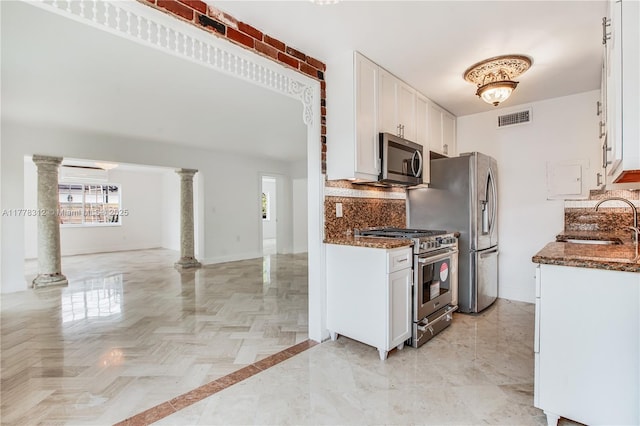 kitchen featuring stainless steel appliances, a sink, a healthy amount of sunlight, decorative columns, and visible vents