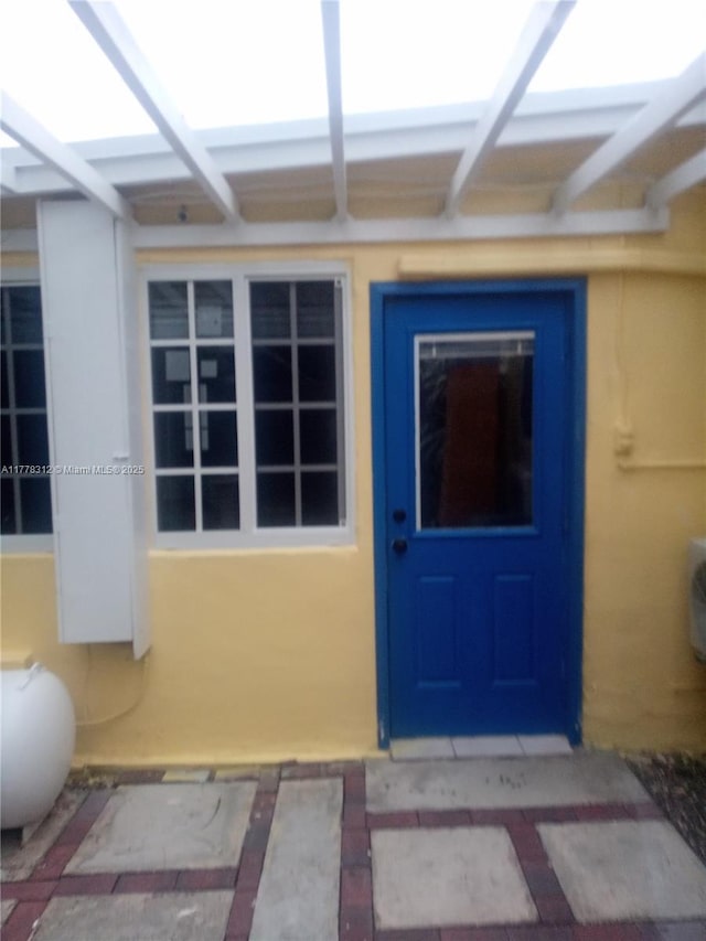 entrance to property featuring stucco siding