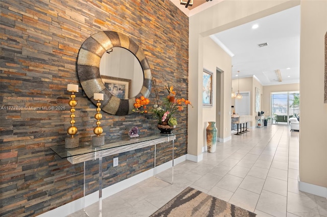 hallway with crown molding, baseboards, and visible vents