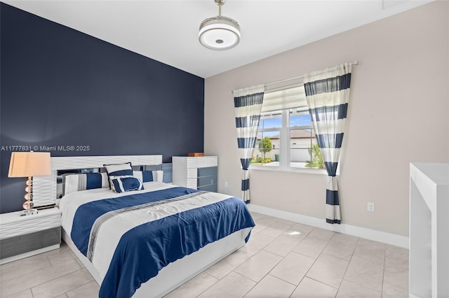 bedroom with baseboards and tile patterned flooring