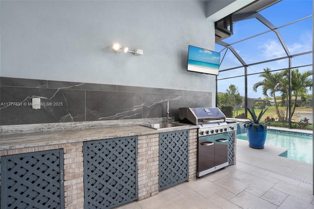 view of patio / terrace with a lanai, a grill, a sink, an outdoor pool, and an outdoor kitchen