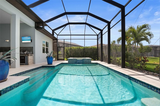 view of pool with a patio area, a pool with connected hot tub, glass enclosure, and area for grilling
