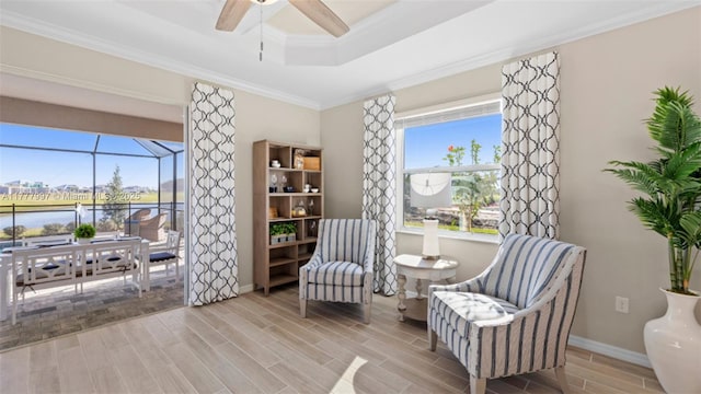 sitting room with plenty of natural light, ornamental molding, ceiling fan, and wood finished floors
