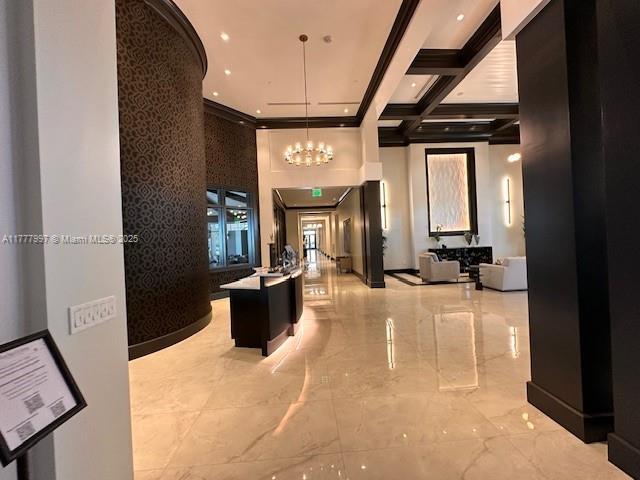 interior space featuring an inviting chandelier, marble finish floor, recessed lighting, beamed ceiling, and coffered ceiling