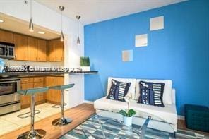 7326 Collins Ave Unit 102, Miami Beach, FL 33141 - kitchen with stainless steel appliances, wood finished floors, dark countertops, and brown cabinetry