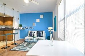 7326 Collins Ave Unit 102, Miami Beach, FL 33141 - living room featuring healthy amount of natural light, wood finished floors, and a ceiling fan