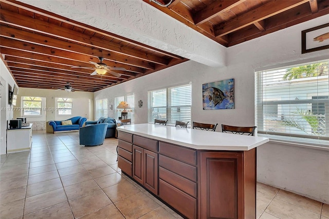 108 Long Ben Dr, Key Largo, FL 33037 - kitchen featuring light tile patterned floors, light countertops, a center island, beamed ceiling, and wood ceiling
