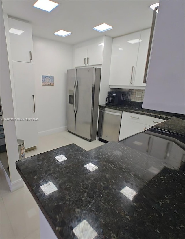 2750 NE 183rd St Unit 301, Aventura, FL 33160 - kitchen featuring baseboards, appliances with stainless steel finishes, white cabinetry, dark stone counters, and decorative backsplash