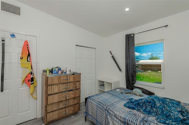 bedroom with light wood-style floors, visible vents, and recessed lighting