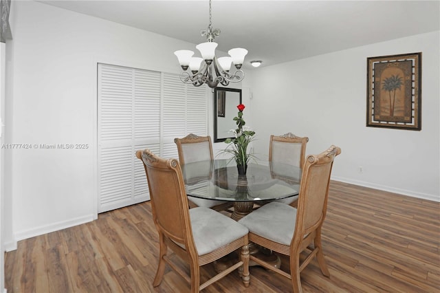 dining space featuring a chandelier, wood finished floors, and baseboards