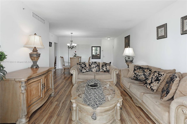 living room with wood finished floors, a notable chandelier, and visible vents