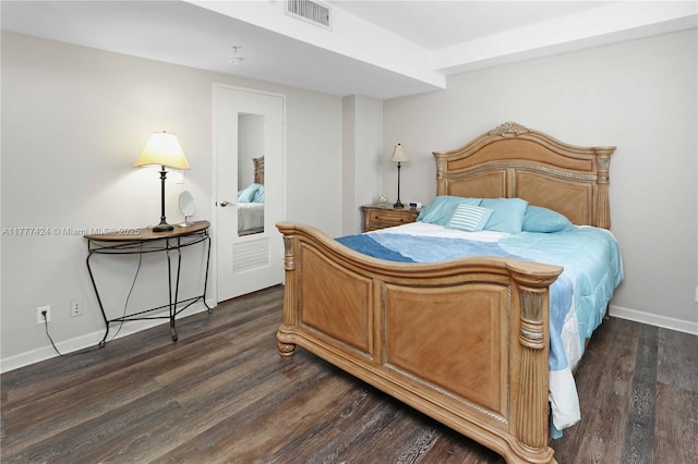 bedroom with visible vents, baseboards, and dark wood finished floors