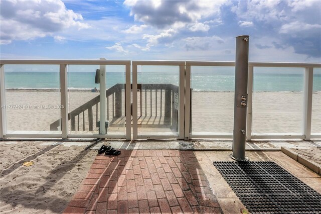 exterior space featuring a balcony, a beach view, and a water view