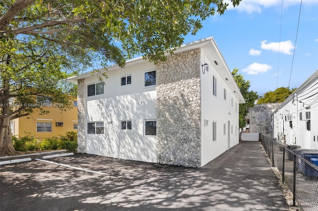 rear view of property with stucco siding and fence