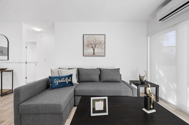 living area with light wood-style floors and a wall mounted AC