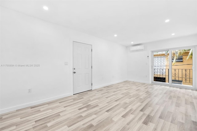 unfurnished living room featuring baseboards, light wood finished floors, a wall mounted AC, and recessed lighting