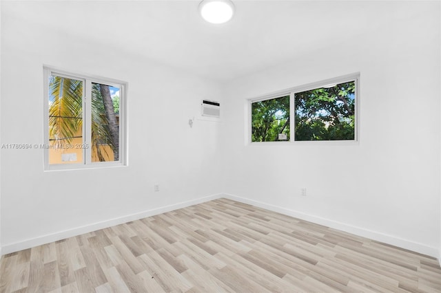 empty room with light wood-style floors, baseboards, and a wealth of natural light