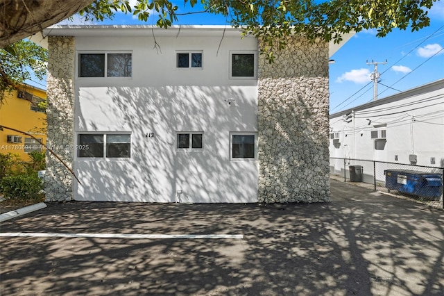back of property featuring stucco siding and fence