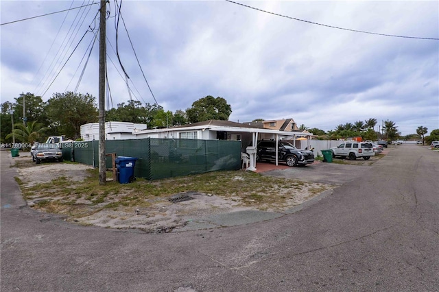 view of front of home with a carport and fence